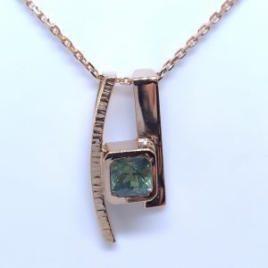 Pendentif or rose et saphir vert
